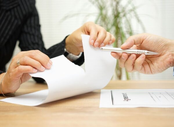51619076 - woman tears agreement documents  in front of agent who wants to get  a signature