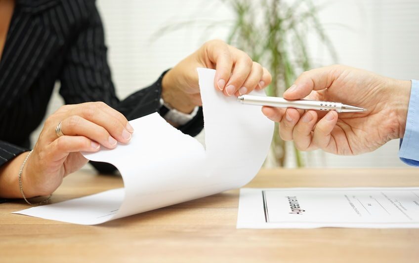 51619076 - woman tears agreement documents  in front of agent who wants to get  a signature